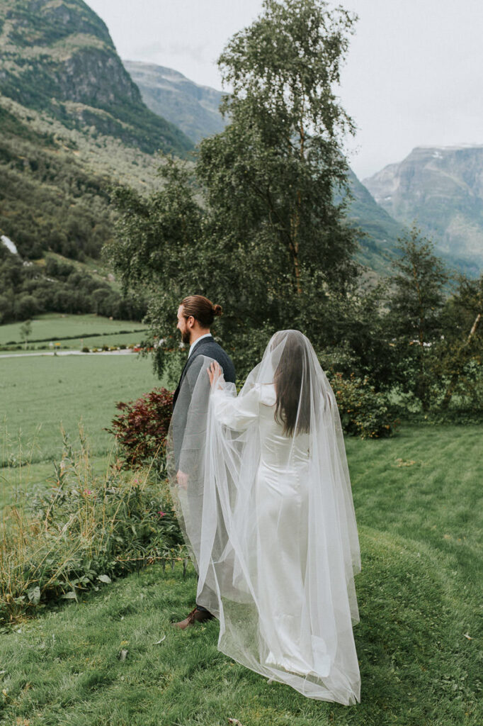 First look on the elopement day in Loen, Western Norway. Bride is approaching the groom from behind and he is utterly happy to see her for the first time