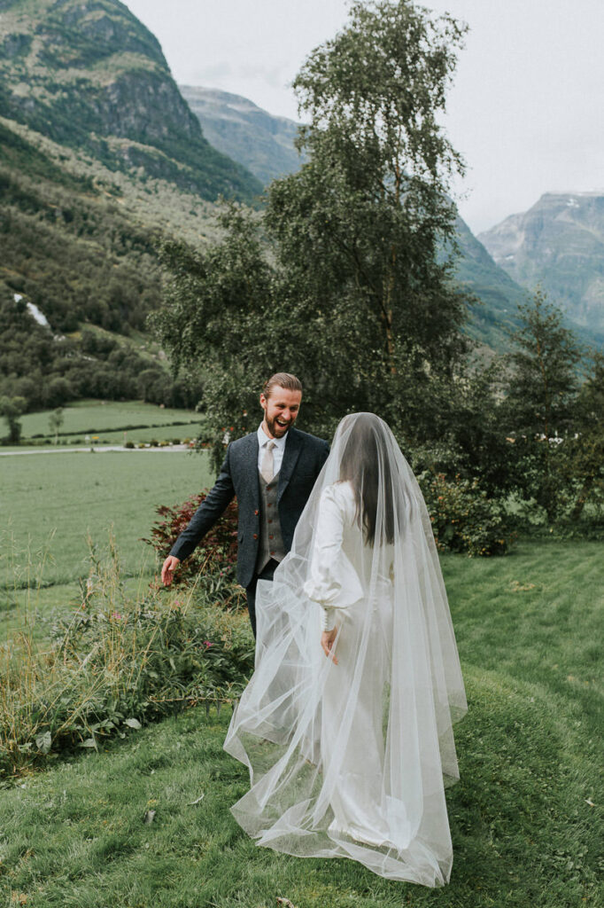 First look on the elopement day in Loen, Western Norway. Bride is approaching the groom from behind and he is utterly happy to see her for the first time