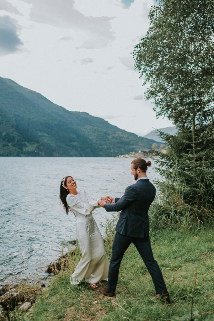 Bride and groom playing around by the lake in western Norway