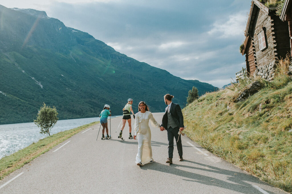 Bride and groom walking in the middle of the road in Loen Western Norway