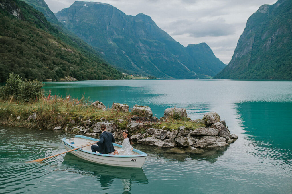 Bride and groom in a rowing boat on a gorgeous blue lake Oldevatnet in Loen Stryn Western Norway