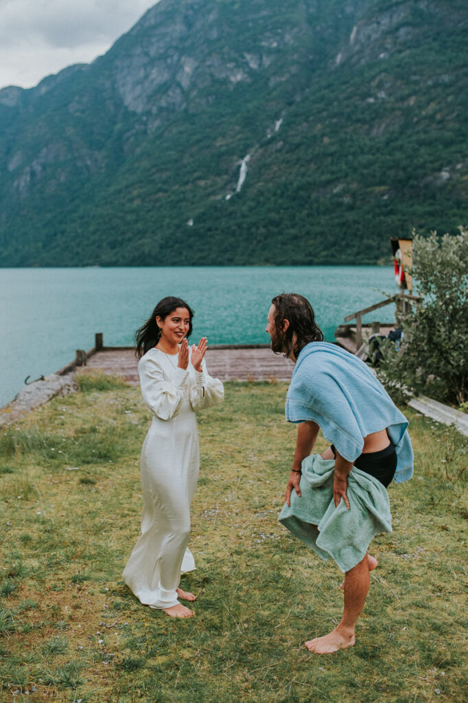 A groom jumped in the lake in Western Norway at the end of their intimate wedding day and bride is helping him to get dry after the swimming