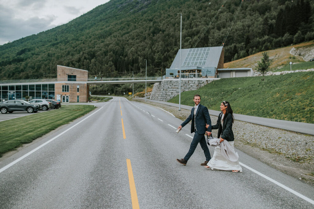 Bridal couple smiling when crossing the road in Loen, with the Loen Skylift in the background