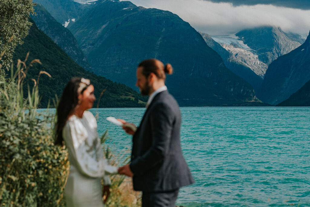 Intimate elopement ceremony by the lake Lovatnet in Loen, Western Norway surrounded by mountains and glaciers. 