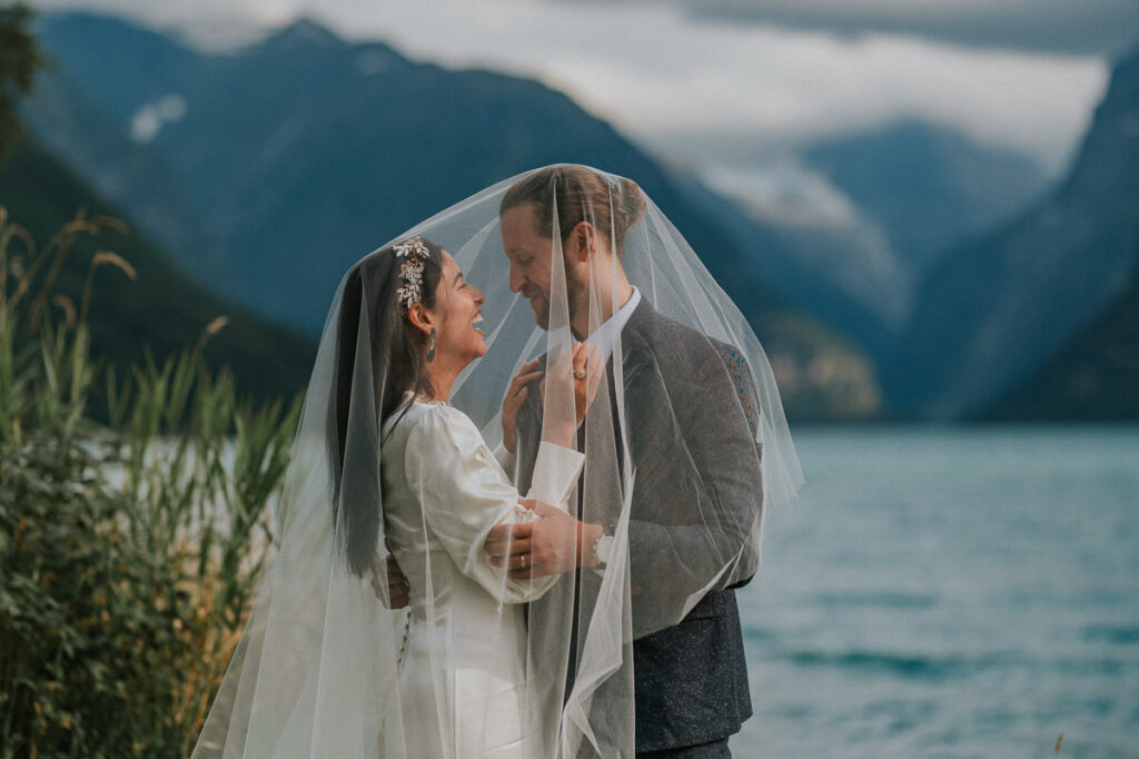 Bride and groom portrait under her veil oudoors in the beautiful nature