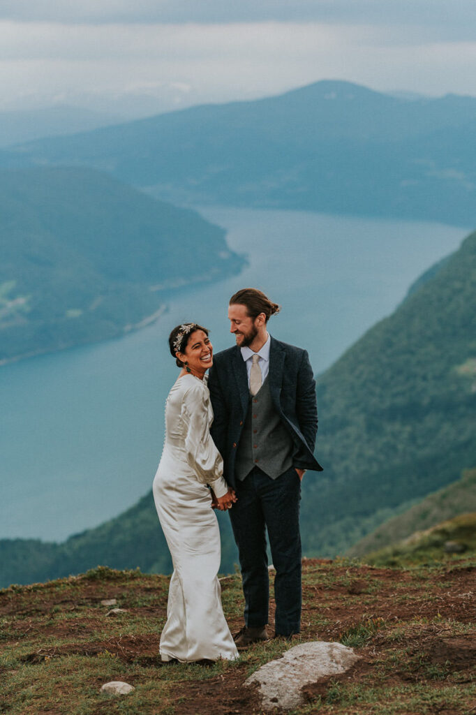 Bridal couple standing on a mountaintop on the day of their elopement in Loen Norway