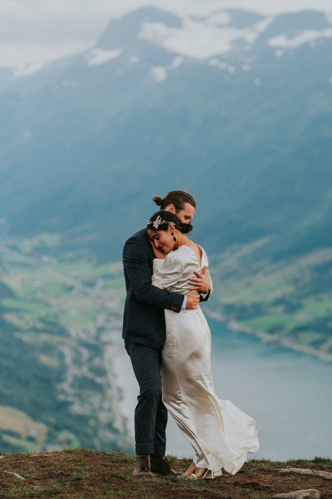 Bride and groom hugging on a mountaintop with a great fjord view in Loen Stryn 