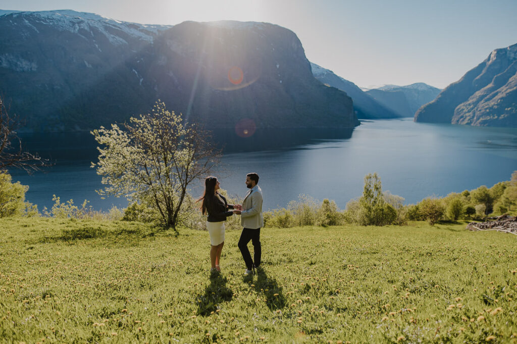 A guy is ready to propose to his girlfriend among beautiful scenery of Aurland. The couple is holding hands and smiling