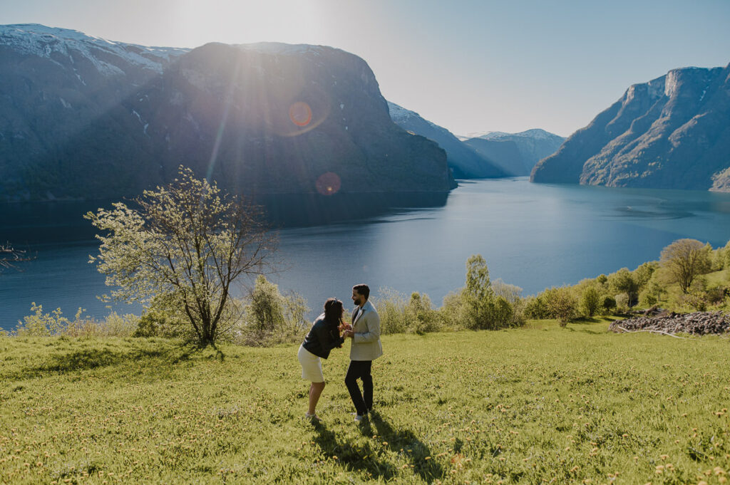 A guy is ready to propose to his girlfriend among beautiful scenery of Aurland in Norway. The couple is holding hands and smiling