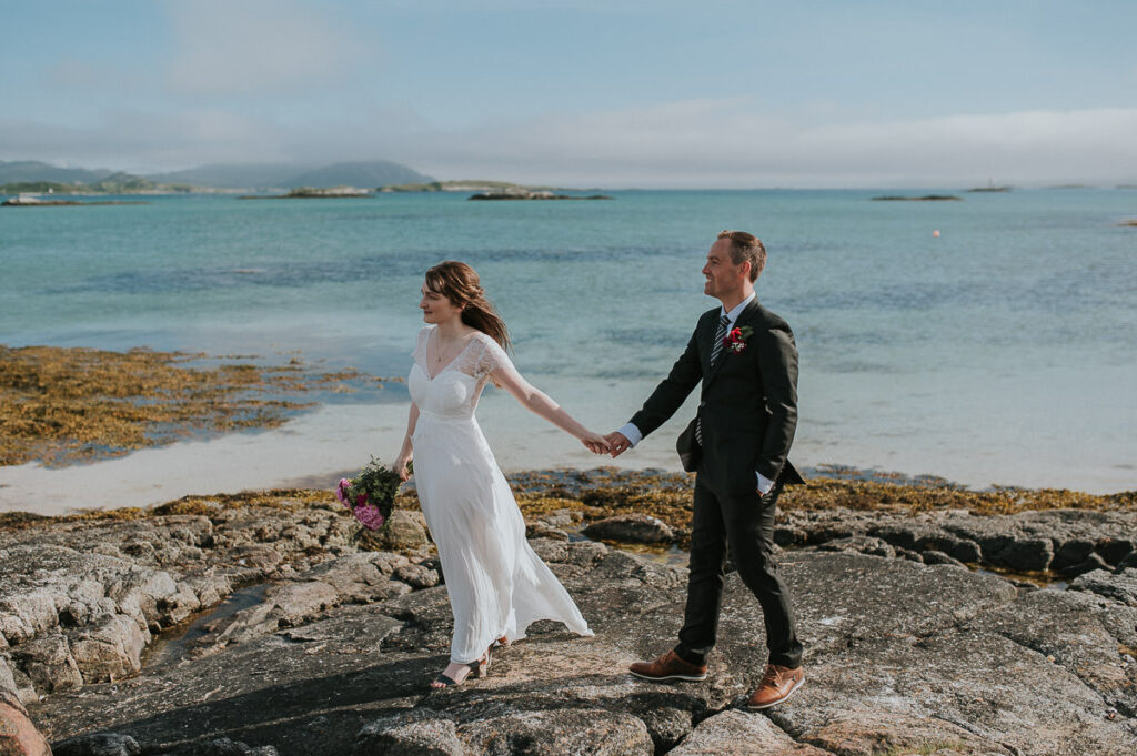 Elopement ceremony on a beautiful beach in Sommarøy island outside of Tromsø. Bride and groom enjoying beautiful sea view and the sunny day