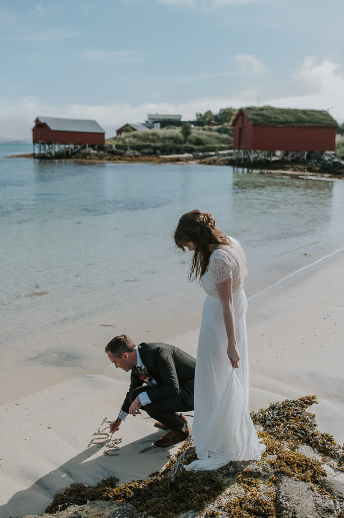 Bride and groom writing a message  Just Married in the sand on a beach on Sommarøy island