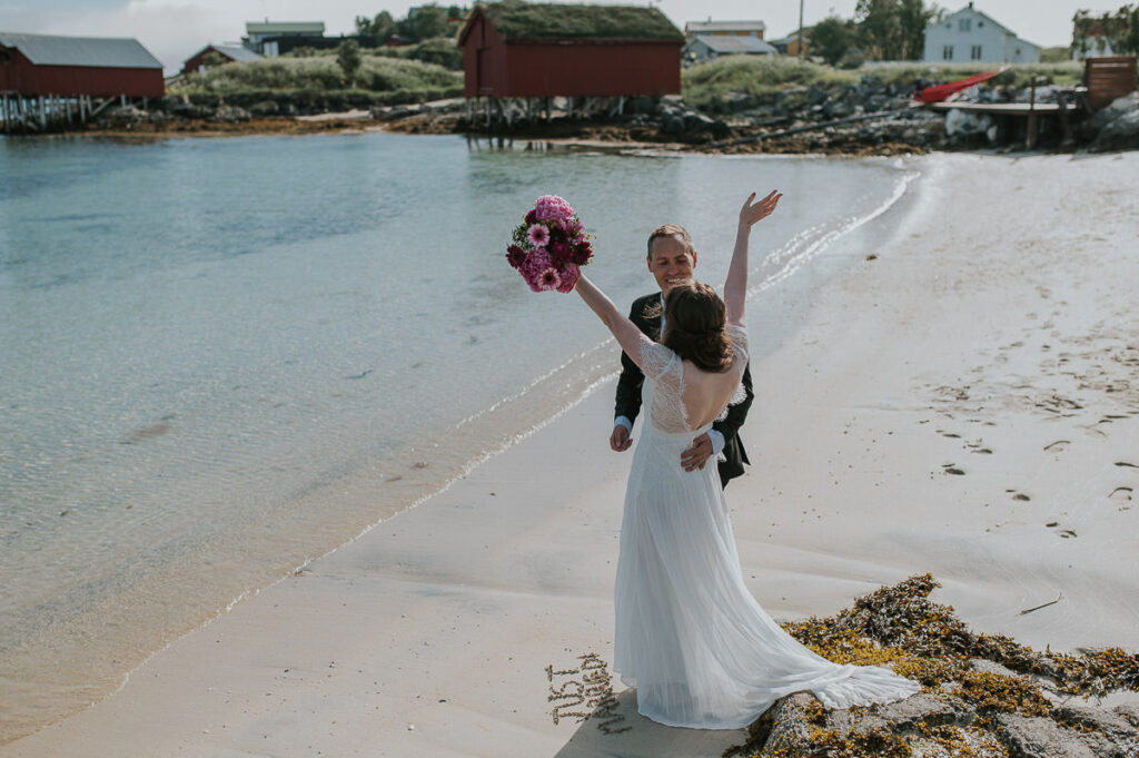 Bride and groom looking happy on a beautiful beach in Norway on a nice sunny day