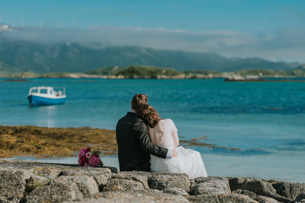 Elopement on a beautiful beach in Sommarøy island outside of Tromsø. Bride and groom enjoying beautiful turquoise sea view and the sunny day