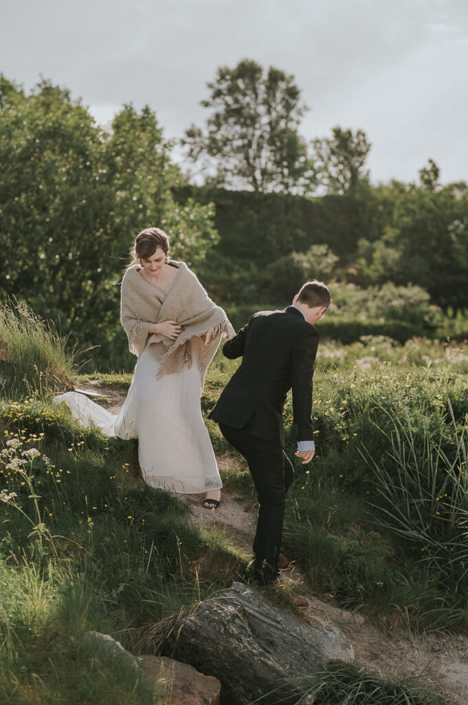 Groom helps his bride to get down to a flower field