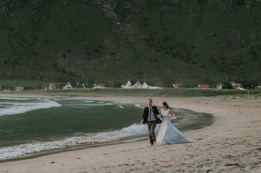 Bride and groom running on a beach 