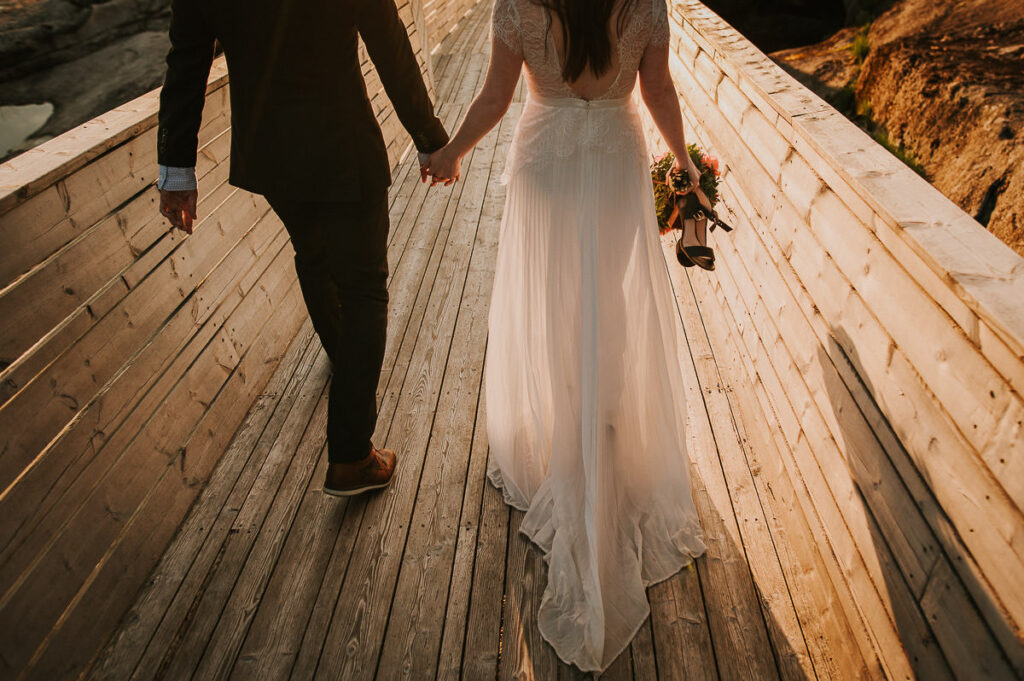 Bridal couple walking while showing their wedding attire in the rays of midnight sun