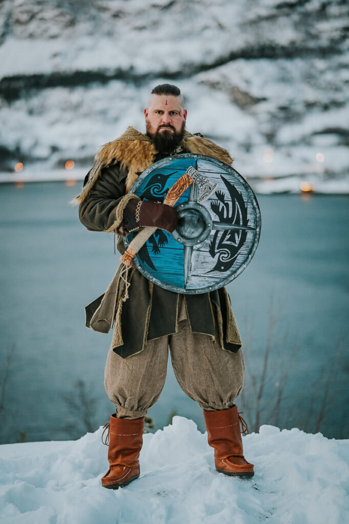 Male viking with a shield and axe in front of a snowy landscape in Alta Norway