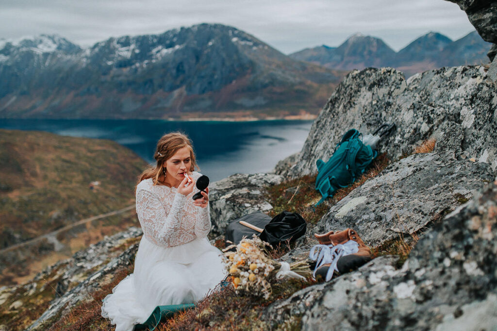 Bride getting ready on a mountaintop in Tromsø putting her makeup on