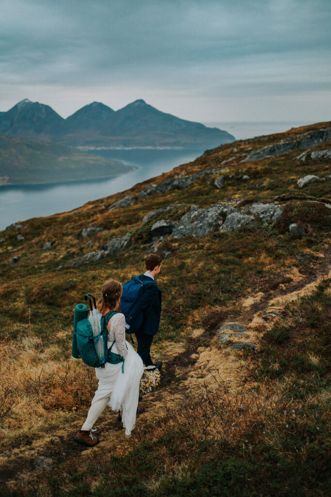 Bride and groom hiking on the day of their fall elopement in Tromsø