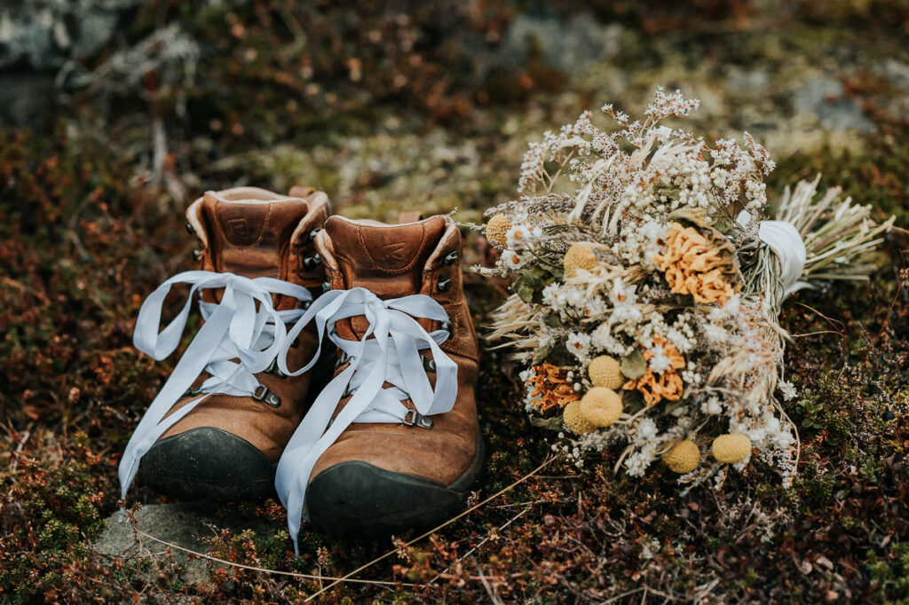 Dried flowers wedding bouquet in yellow tones and hiking boots decorated with white shoelaces
