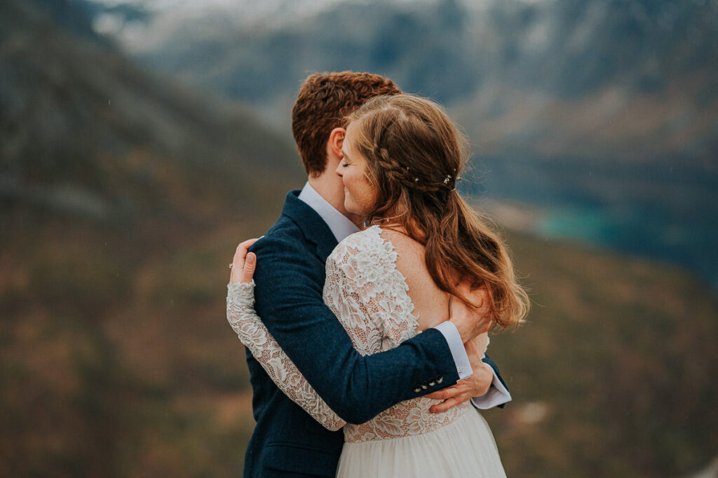 Bride and groom hugging each other on a mountaintop