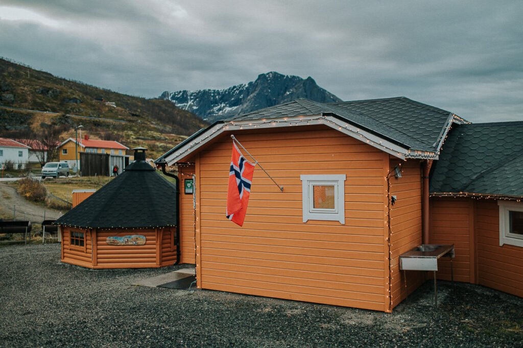 Norwegian flag hanging on a yellow orange cabin on a beach in Tromsø to mark a wedding celebration