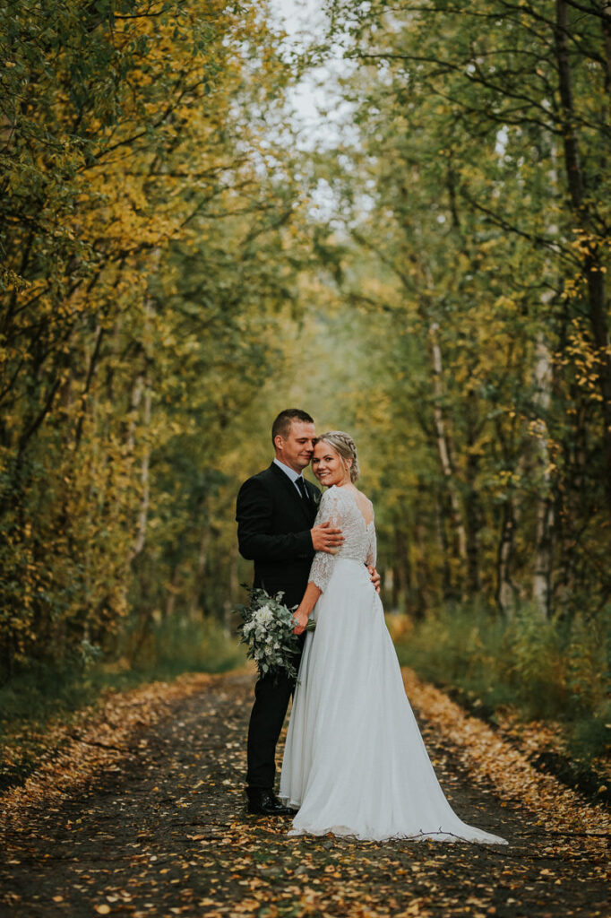 Nydelig brudepar spaserer i en høstkledd skog  - beste foto locations for bryllup i Alta