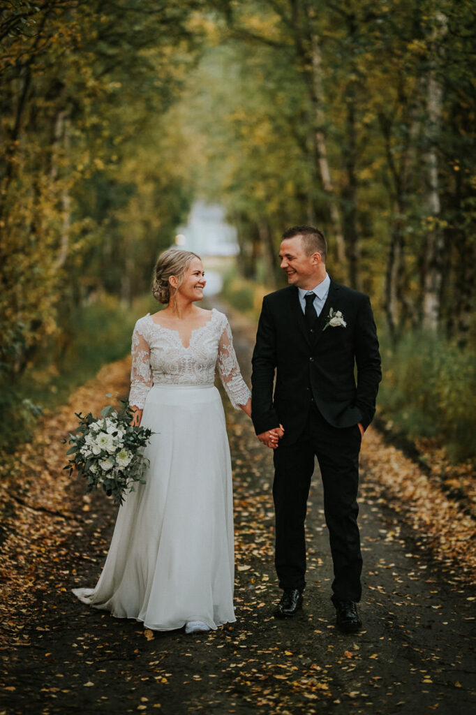 Nydelig brudepar spaserer i en høstkledd skog  - beste foto locations for bryllup i Alta
