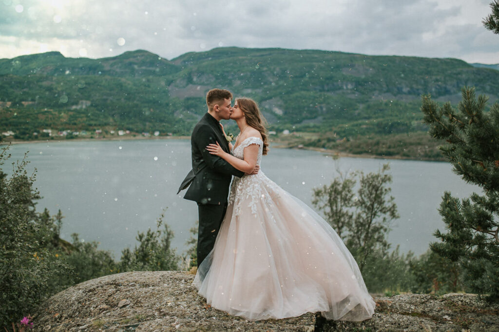 Nydelig brudepar kysser foran utsikt til fjord og fjell - beste foto locations for et bryllup i Alta