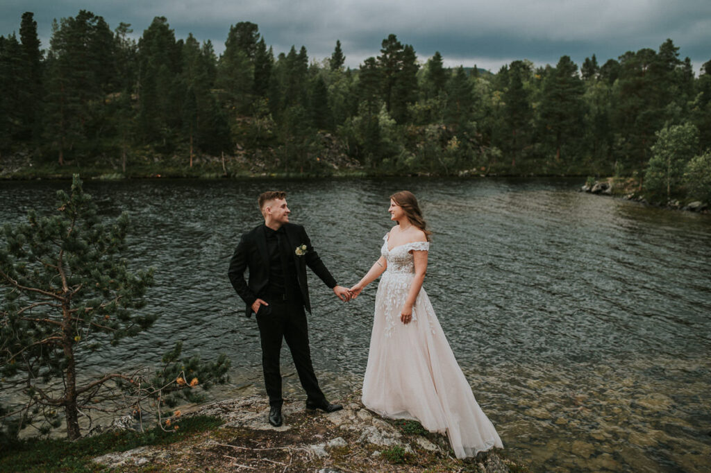 Nydelig brudepar spaserer foran et innsjø i Alta - beste foto locations for et bryllup i Alta
