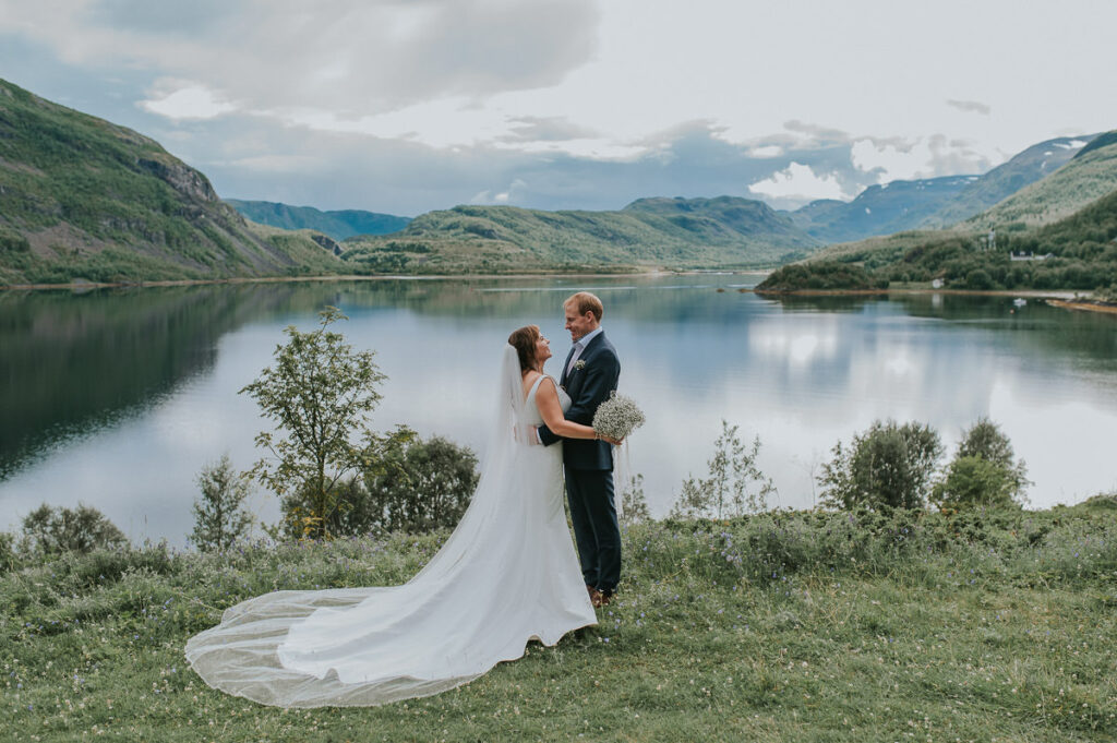 Fint brudepar ser hverandre i øynene foran fjord utsikt utenfor Alta - beste foto locations for et bryllup i Alta