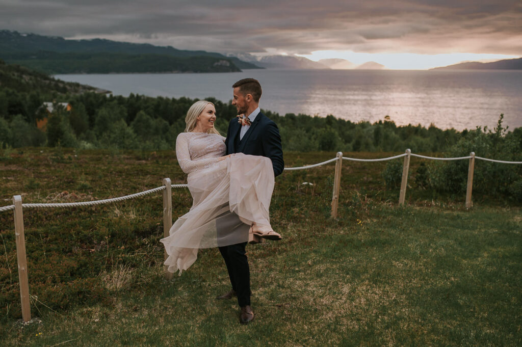 Nydelig brudepar klemmer hverandre i solnedgang i Alta