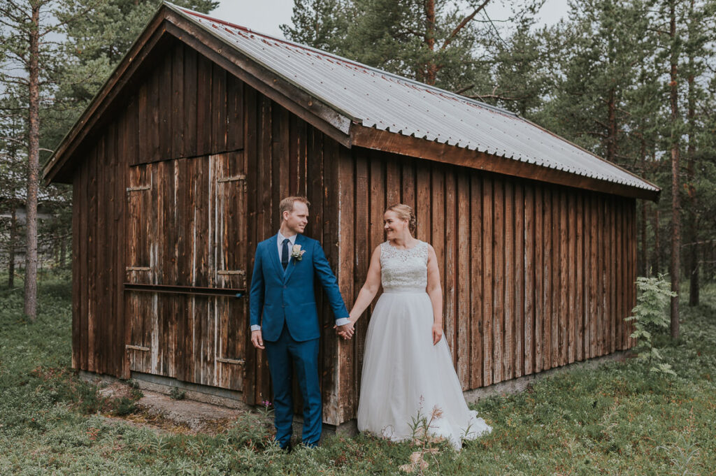 brudepar poserer foran et gammelt skjå  i en skog i Alta