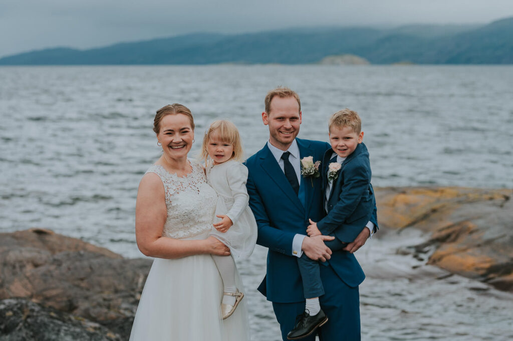 brudepar poserer sammen med sine barn på bryllupsdagen sin foran fjord og fjell i Alta