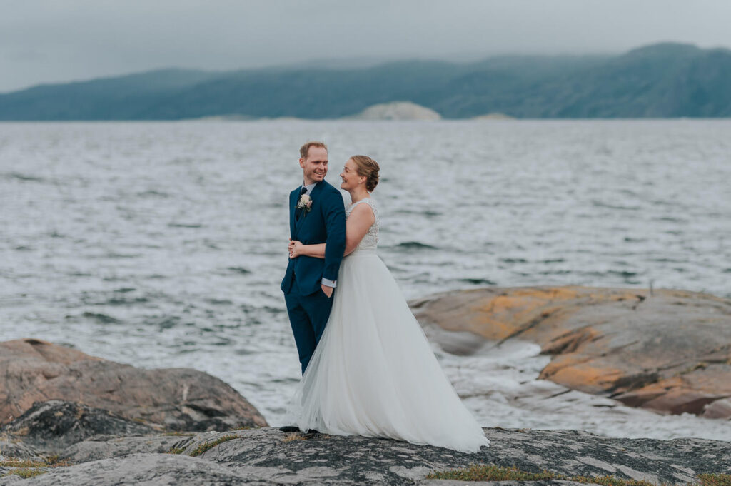 brudepar poserer  på bryllupsdagen sin foran fjord og fjell i Alta