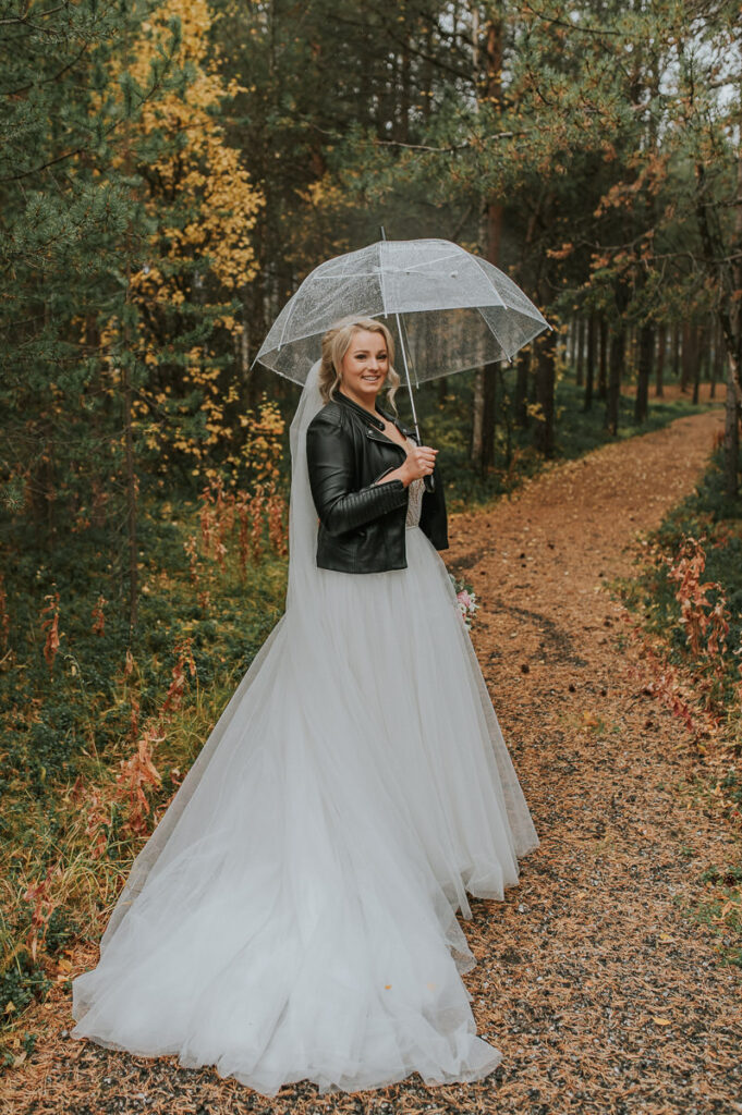 Nydelig brud med en skinnjakke i en høstkledd skog - beste foto locations for bryllup i Alta