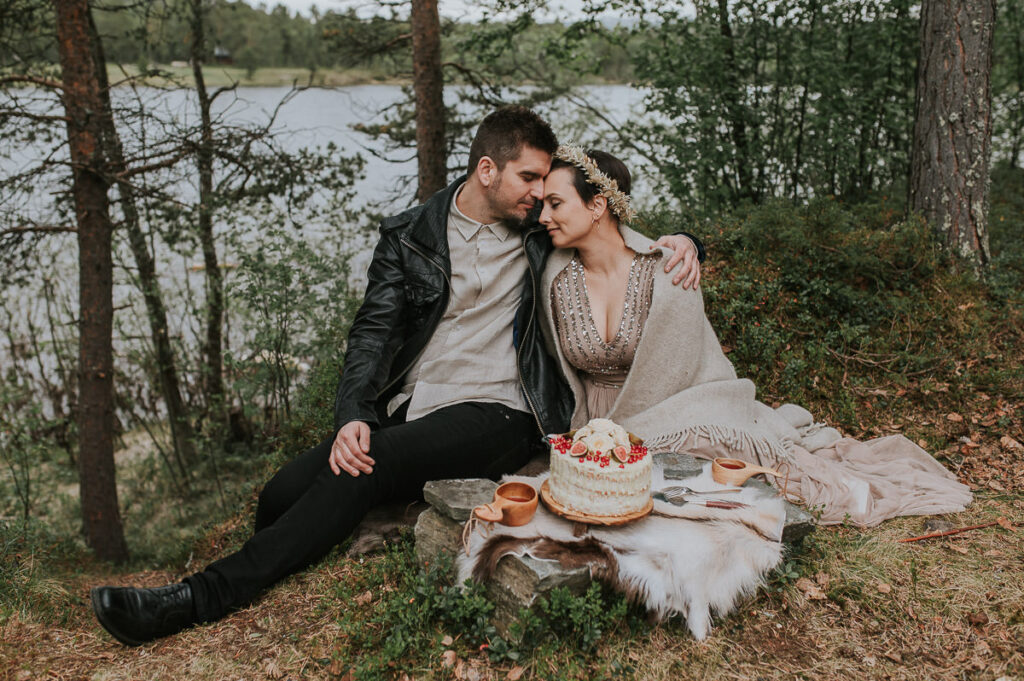 Nydelig brudepar i en skog i Alta spiser bryllupskaken sin