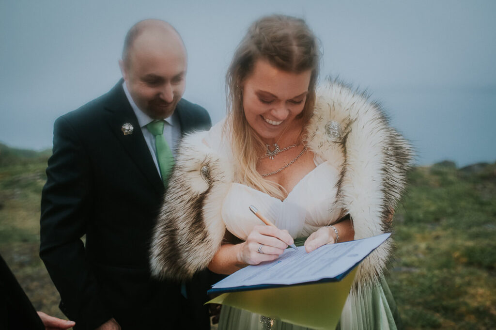 Bride and groom signing papers after their legally binding wedding ceremony in Norway