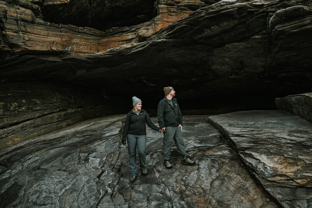 A couple holding hands in the cave on Sørøya in Nprway