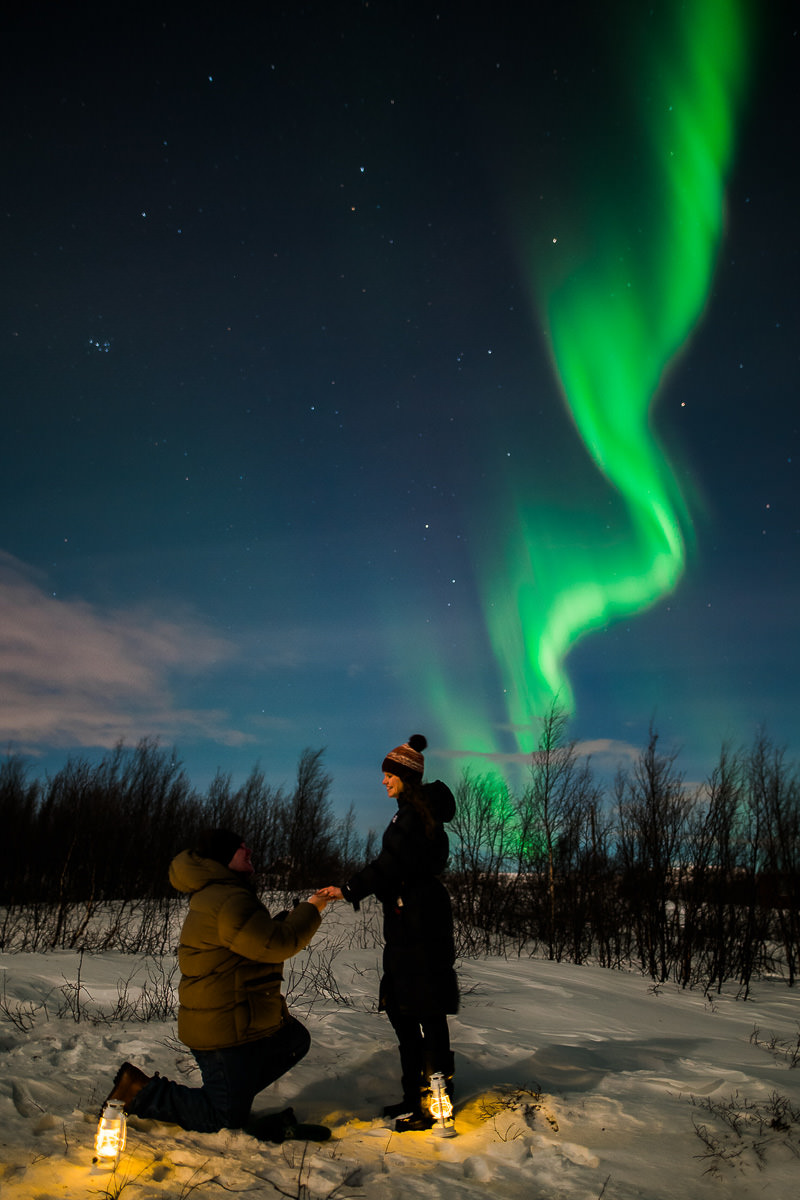 A guy propsing to his girlfriend under the northern lights in Alta Norway