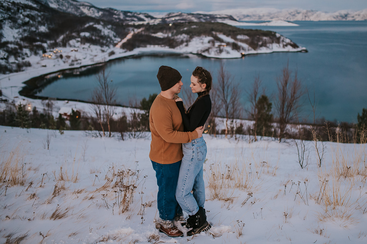 A couple hugging each other among snowy landscapes of Alta in Norway