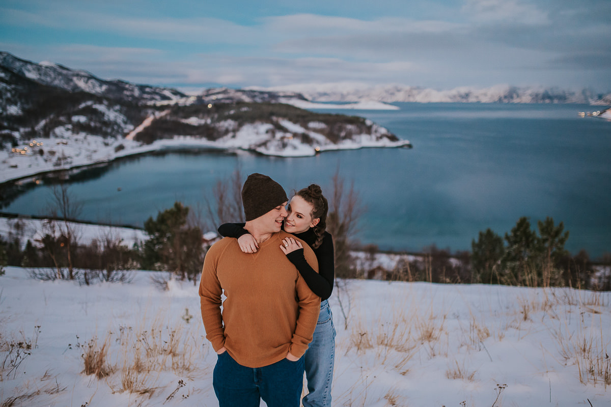 A couple hugging each other among snowy landscapes of Alta in Norway