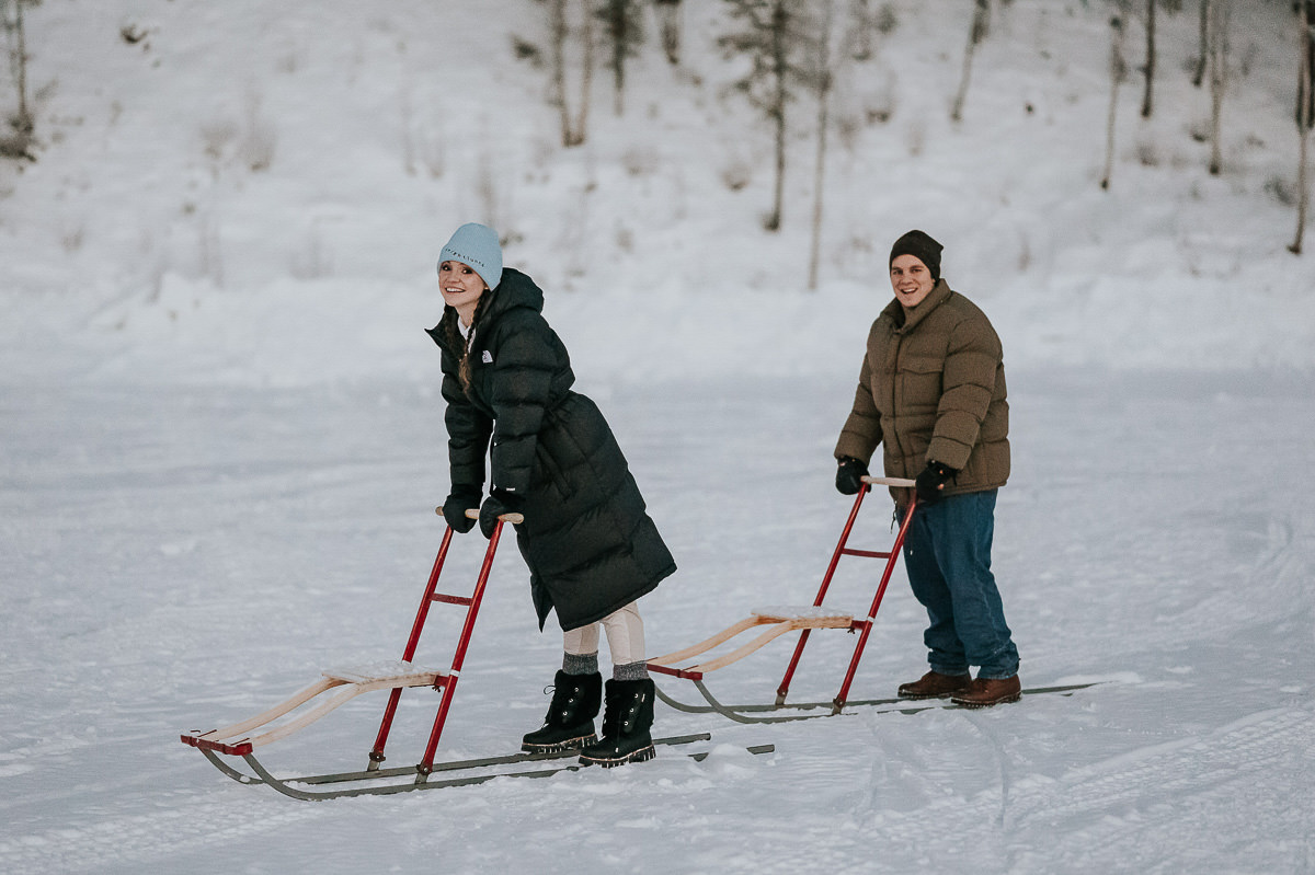 A couple trying out kicksledding in Norway