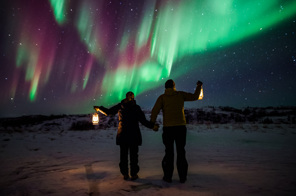 A couple watching a great northern lights show in Alta Norway