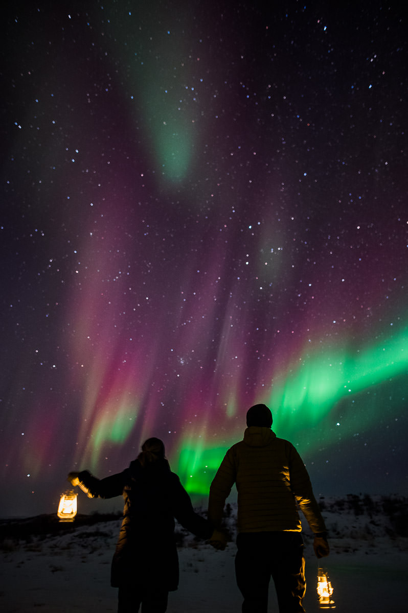 A couple watching a great northern lights show in Alta Norway