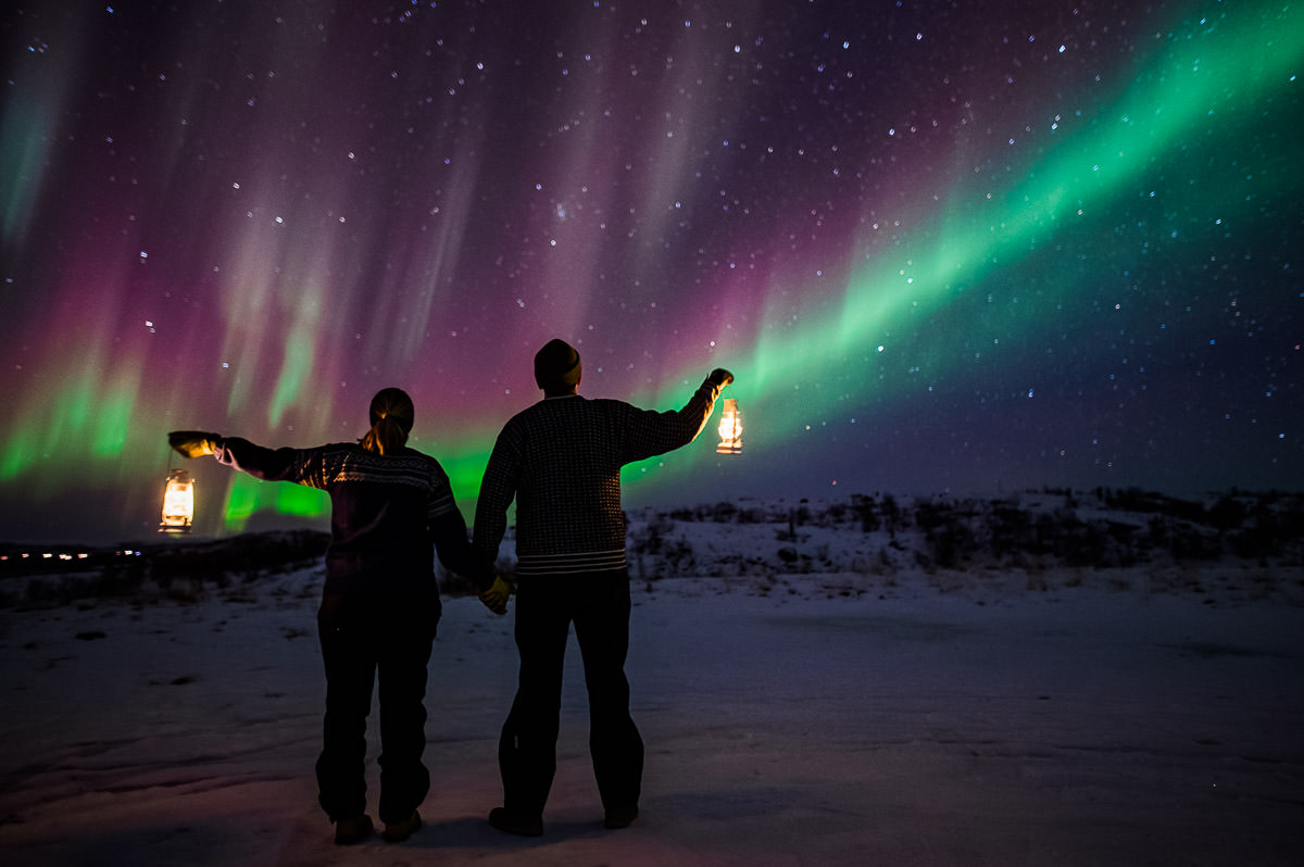 A couple watching a great northern lights show in Alta Norway