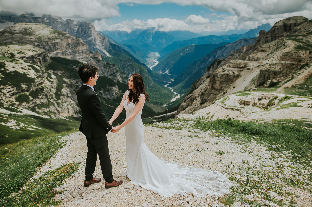 Bride and groom in the mountains Tre Cime di Lavaredo in Italian Dolomites on a sunny summer day