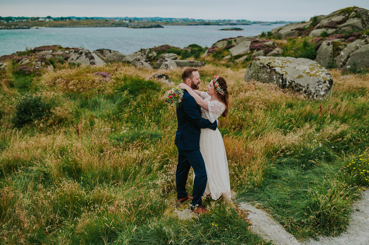 Utendørs sommerbryllup i Haugesund - brudeparet på et fint stråfelt i nærheten av stranda