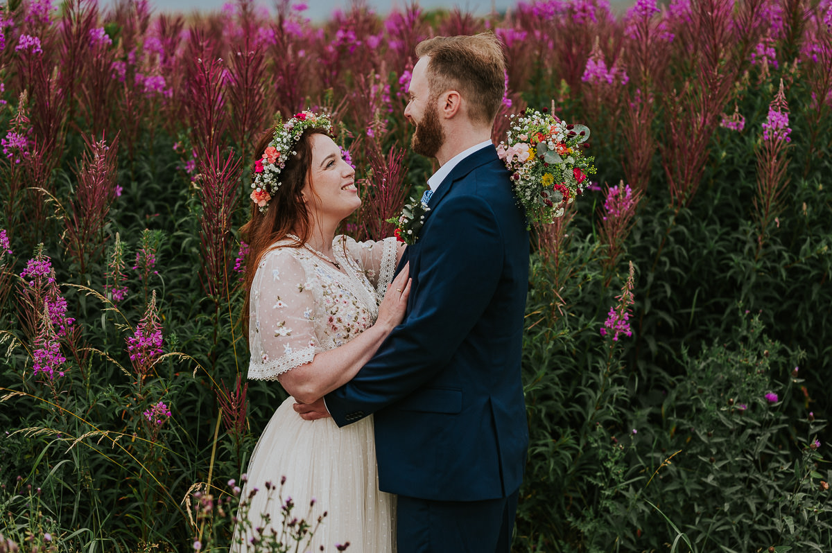 Utendørs sommerbryllup i Haugesund - brudeparet i en nydelig blomstereng omringet av geitrams