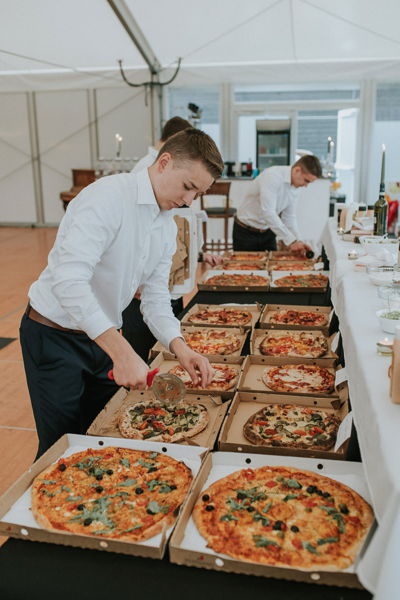 Bryllupsfest på Kvenvik i Alta - servitørene skjærer pizza som skal serveres til middag